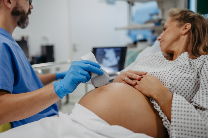 Photo shows ob/gyn doctor performing an ultrasound on a pregnant woman/Getty Images